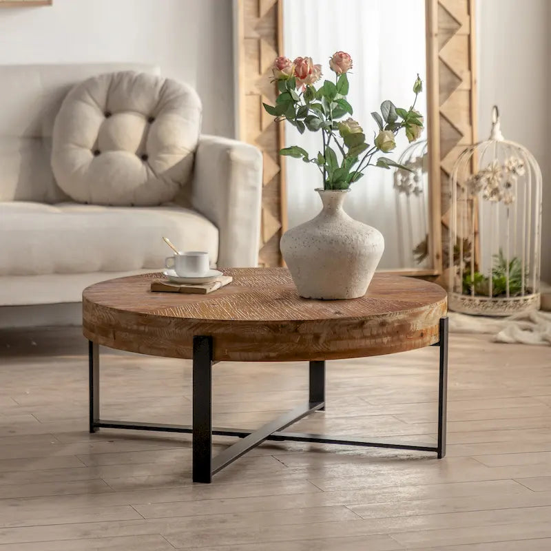 Table basse ronde moderne rétro avec plateau en bois de sapin et piètement croisé noir, idéale pour le salon.