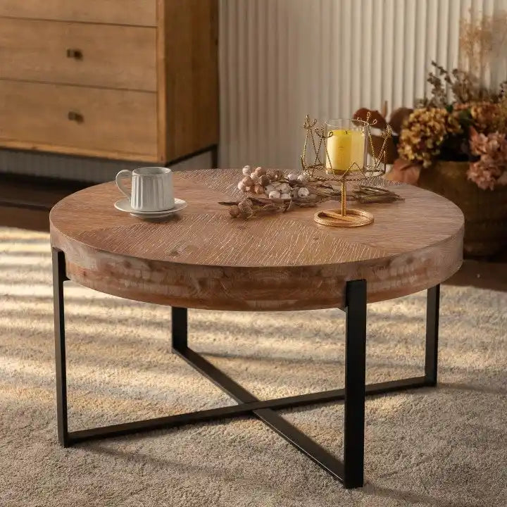 Table basse ronde moderne rétro avec plateau en bois de sapin et piètement croisé noir, idéale pour le salon.