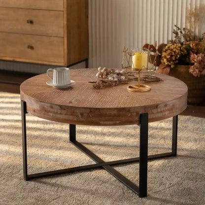 Table basse ronde moderne rétro avec plateau en bois de sapin et piètement croisé noir, idéale pour le salon.