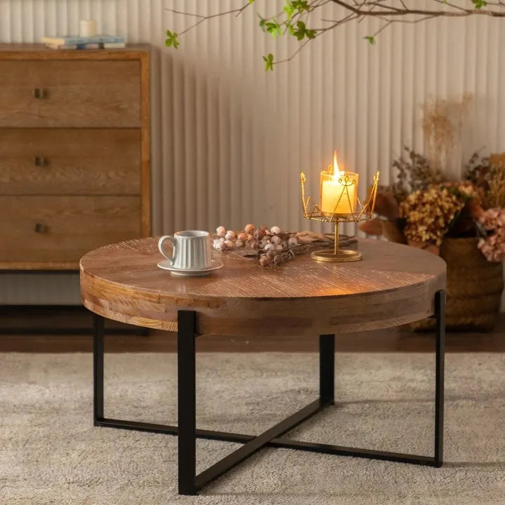 Table basse ronde moderne rétro avec plateau en bois de sapin et piètement croisé noir, idéale pour le salon.
