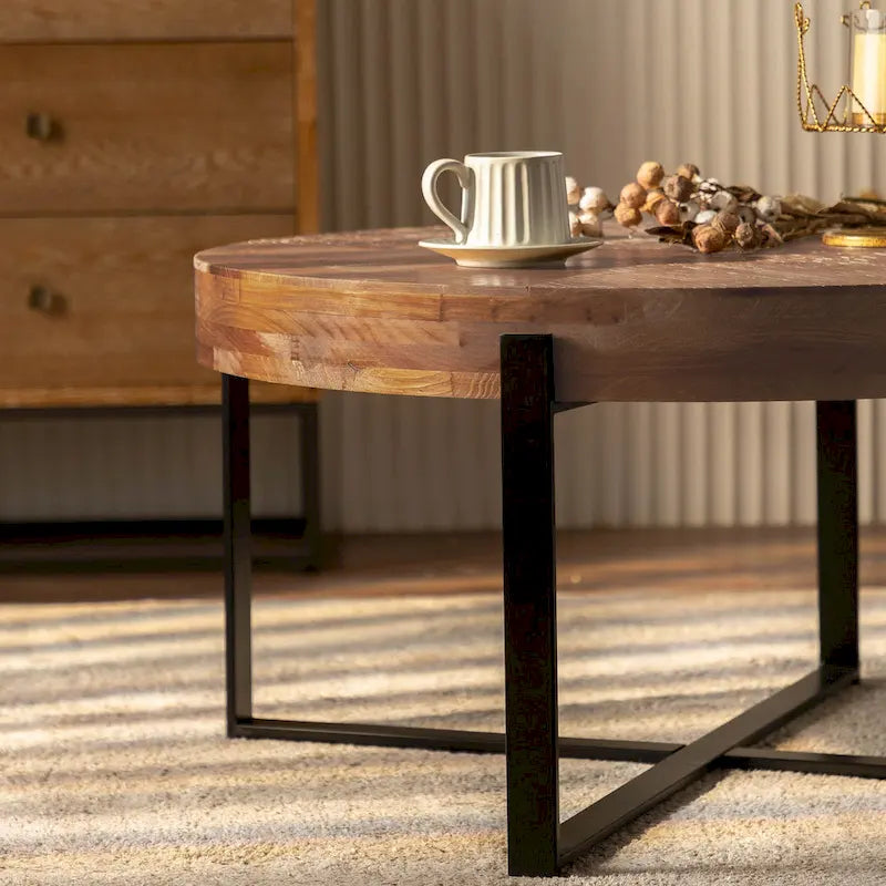 Table basse ronde moderne rétro avec plateau en bois de sapin et piètement croisé noir, idéale pour le salon.