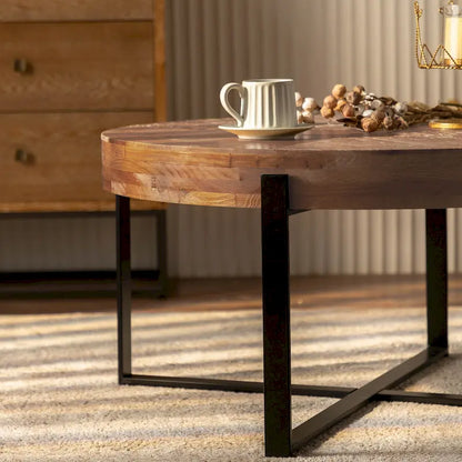 Table basse ronde moderne rétro avec plateau en bois de sapin et piètement croisé noir, idéale pour le salon.