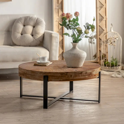 Table basse ronde moderne rétro avec plateau en bois de sapin et piètement croisé noir, idéale pour le salon.