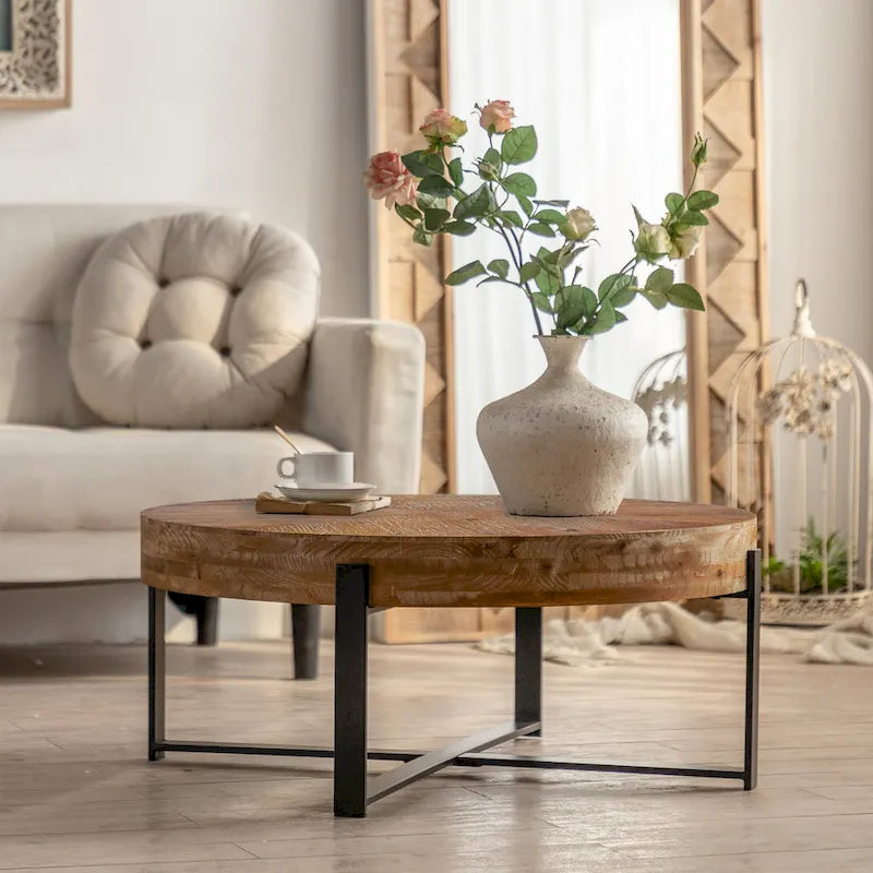 Table basse ronde moderne rétro avec plateau en bois de sapin et piètement croisé noir, idéale pour le salon.