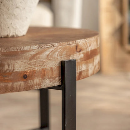 Table basse ronde moderne rétro avec plateau en bois de sapin et piètement croisé noir, idéale pour le salon.