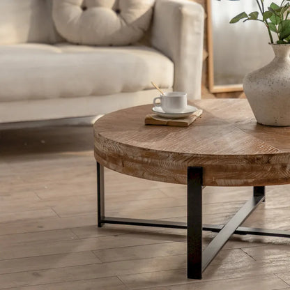 Table basse ronde moderne rétro avec plateau en bois de sapin et piètement croisé noir, idéale pour le salon.